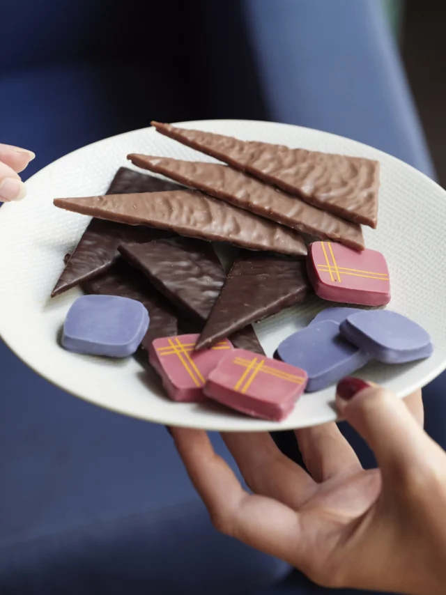 Assiette pleine de chocolats, une main la porte et une main se sert