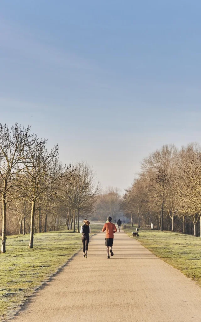 Plan large de deux coureurs dans le parc Balzac en hiver