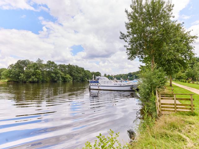 Towpath along the river of the Mayenne and a ship at the dock