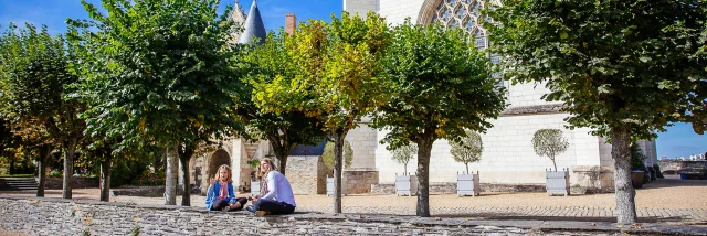 Une mère et sa fille assises sur un muret dans l'enceinte du château