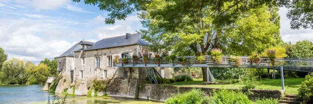 Wide shot of the mill on the banks of the Loir, spring sunshine, nice green vegetation