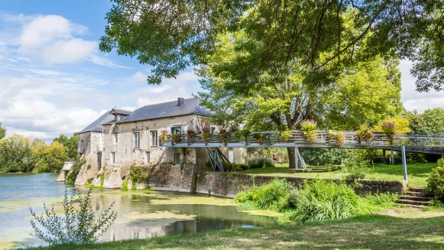 Wide shot of the mill on the banks of the Loir, spring sunshine, nice green vegetation