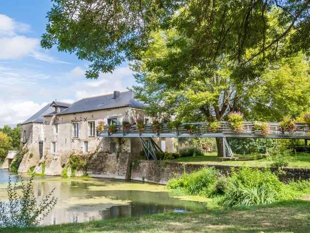 Wide shot of the mill on the banks of the Loir, spring sunshine, nice green vegetation