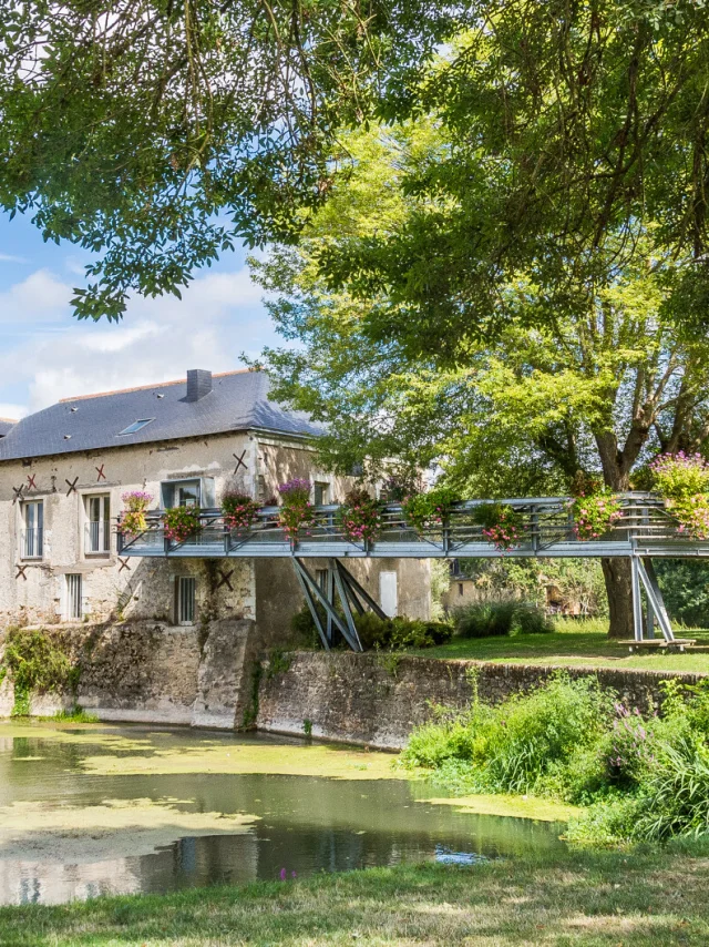 Wide shot of the mill on the banks of the Loir, spring sunshine, nice green vegetation