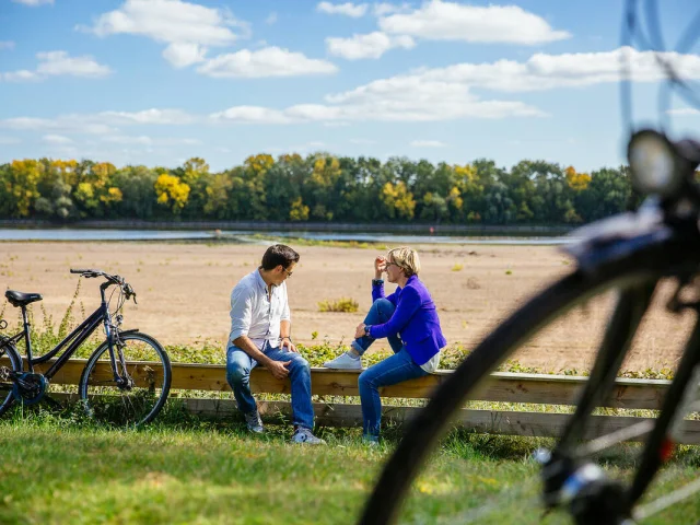 A couple sat on the Loire banks with their bike beside