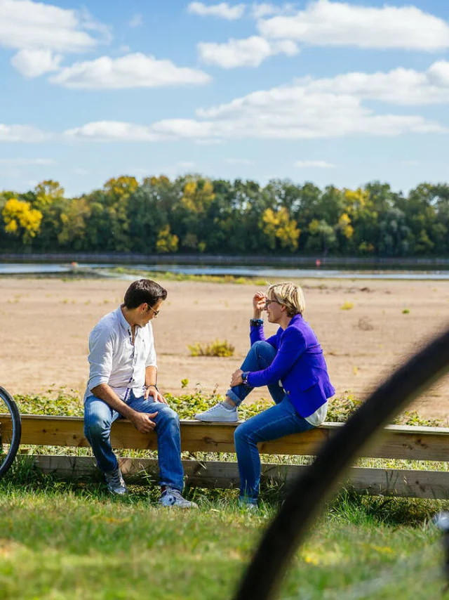 A couple sat on the Loire banks with their bike beside