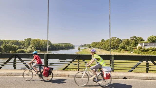 2 cyclistes passant à vélo sur un pont