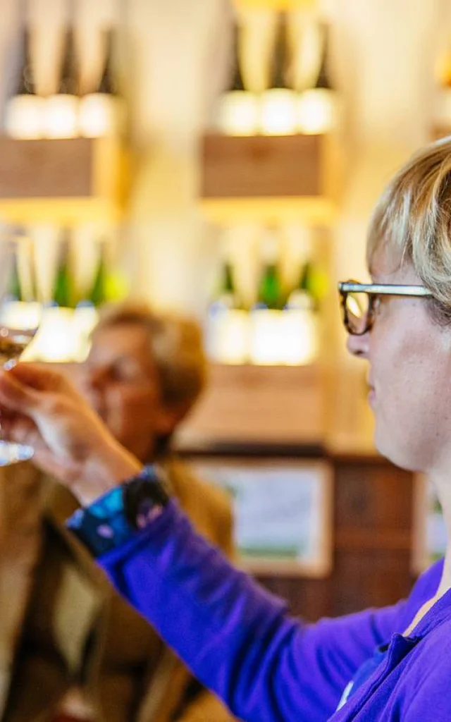 Femme regardant un verre de vin blanc