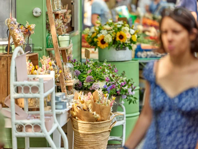 Femme devant un stand de fleurs au marché de la place Lafayette