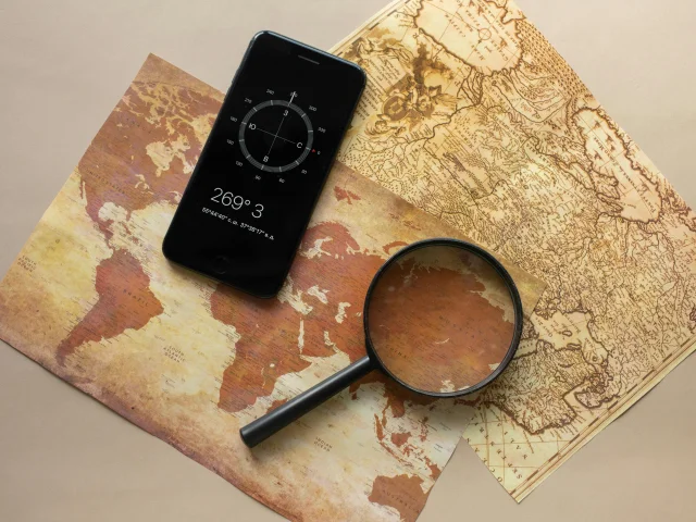 Carte ancienne, loupe et boussole sur le téléphone