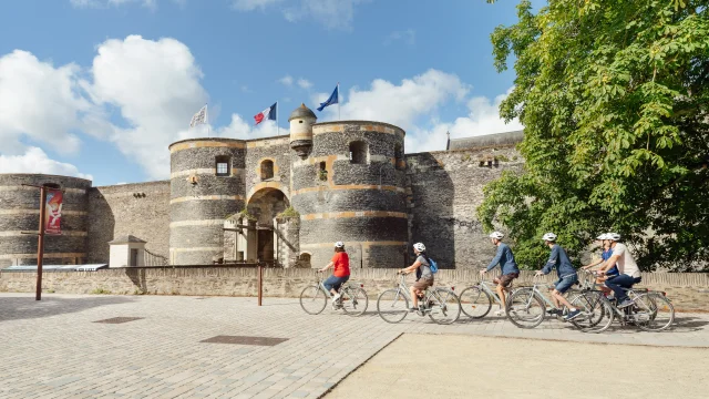 5 personnes à vélo passent devant le château d'Angers