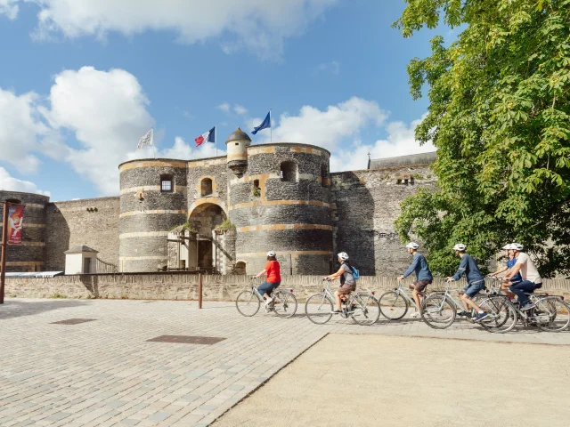 5 personnes à vélo passent devant le château d'Angers