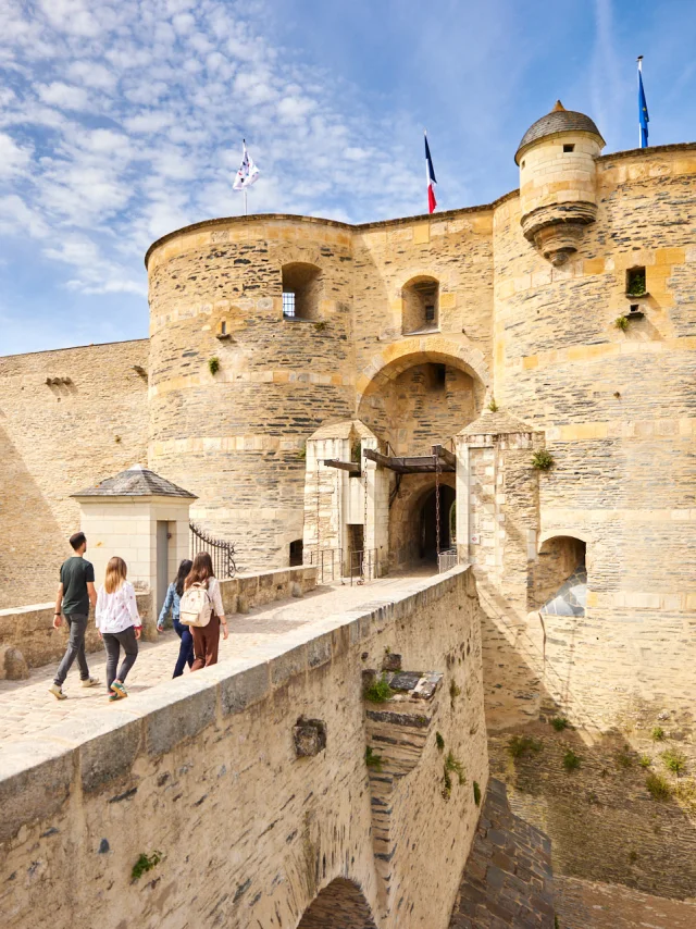 4 personnes entrant dans le château d'Angers, ciel bleu et soleil