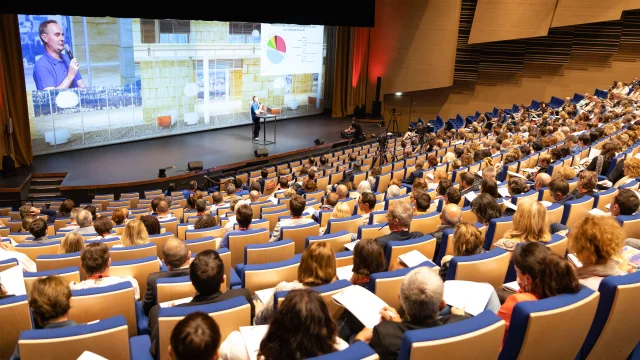 Personnes assistant à une conférence dans le grand auditorium