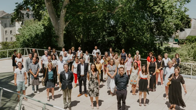 Photo de groupe de personnes réunies sur une terrasse et prise en plongée