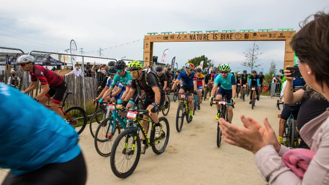 Départ de l'épreuve de gravel, personnes sur les côtés en train d'applaudir les cyclistes