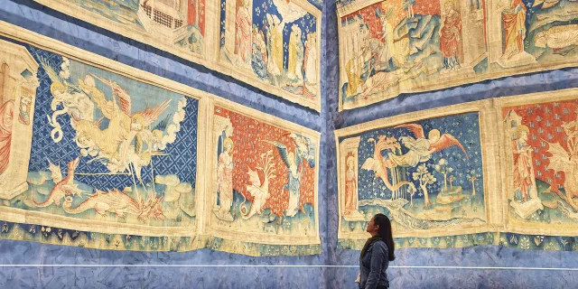 Une femme devant la Tapisserie de l'Apocalypse