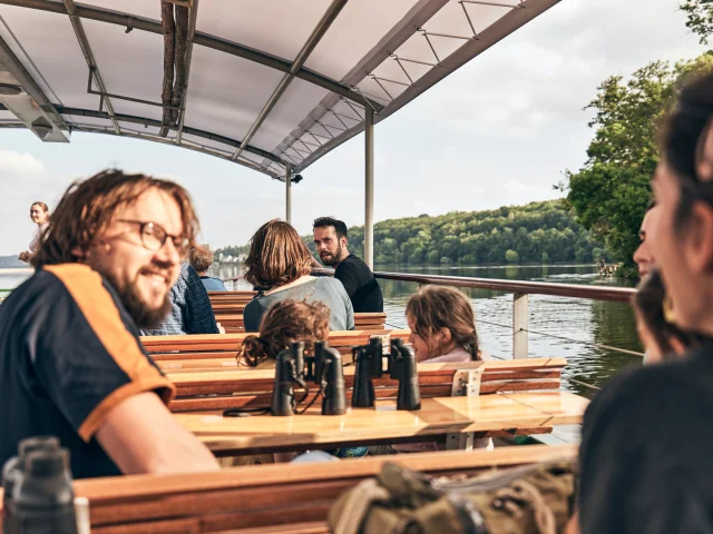 Plusieurs personnes à bord d'un bateau couvert qui navigue sur la Loire