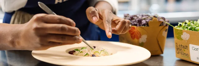 Plan rapproché d'un cuisinier qui dresse une assiette