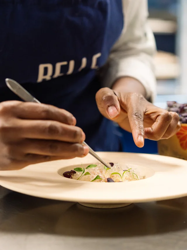 Plan rapproché d'un cuisinier qui dresse une assiette