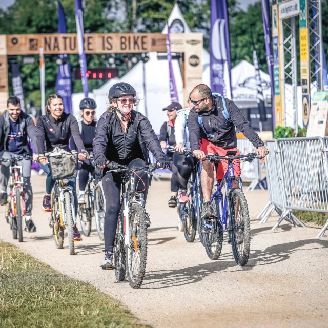 plusieurs personnes partent à vélo sous l'arche de l'événement