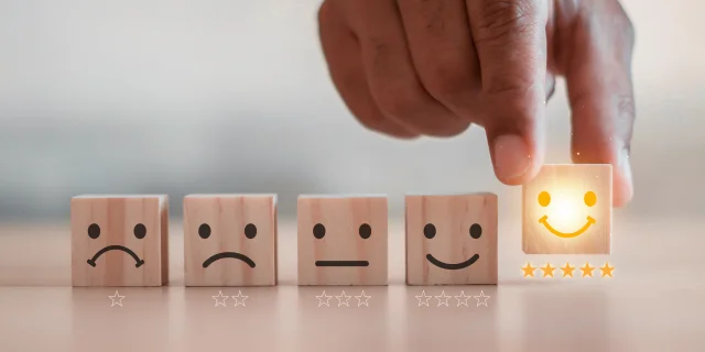 customer services best excellent business rating experience. Satisfaction survey concept. Hand of a businessman chooses a smiley face on wood block cube. 5 Star Satisfaction