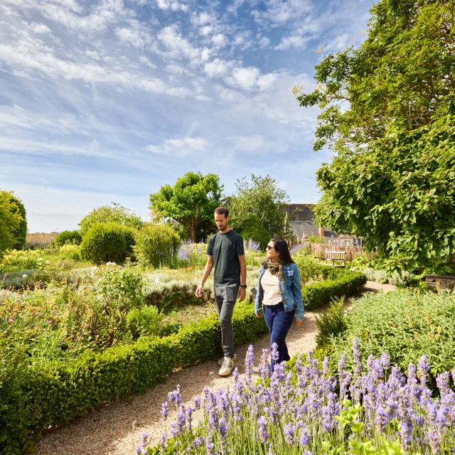 Un homme et une femme se baladent dans les jardins du château d'Angers