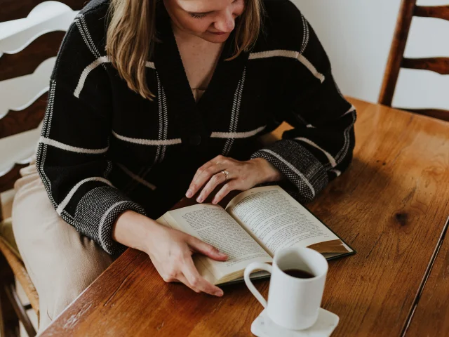 Femme qui lit un livre dans un café