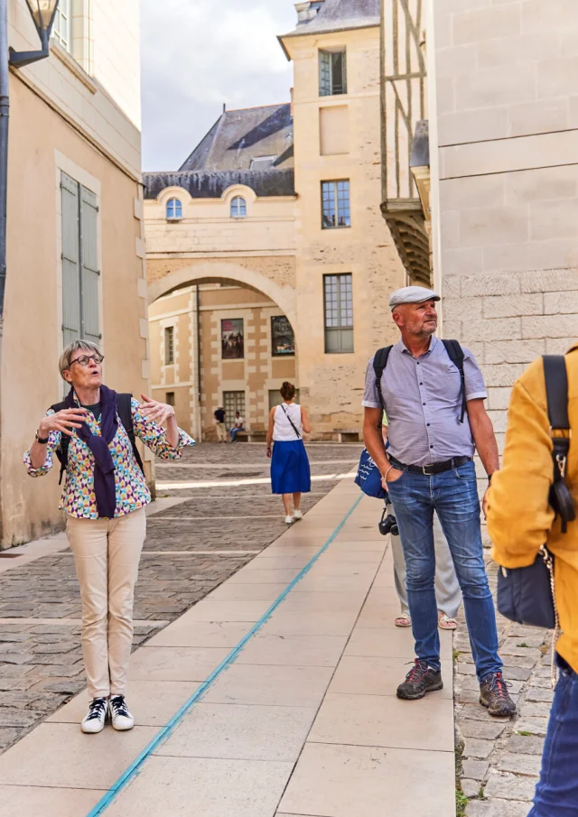 Groupe de seniors écoutant les explications de la guide conférencière dans une rue d'Angers