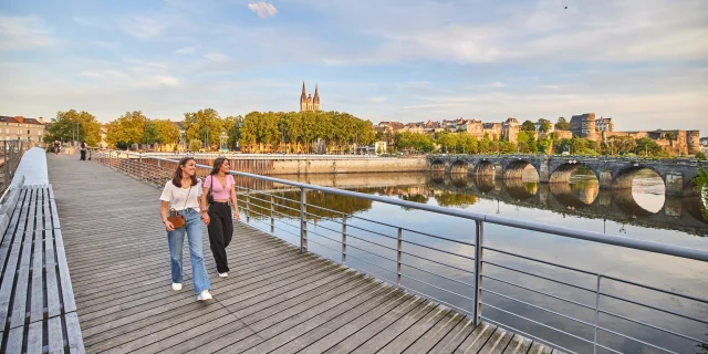 Deux jeunes femmes en tee-shirts, marchant sur le pont en fin de journée