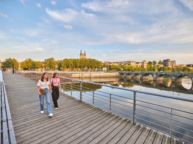 Deux jeunes femmes en tee-shirts, marchant sur le pont en fin de journée