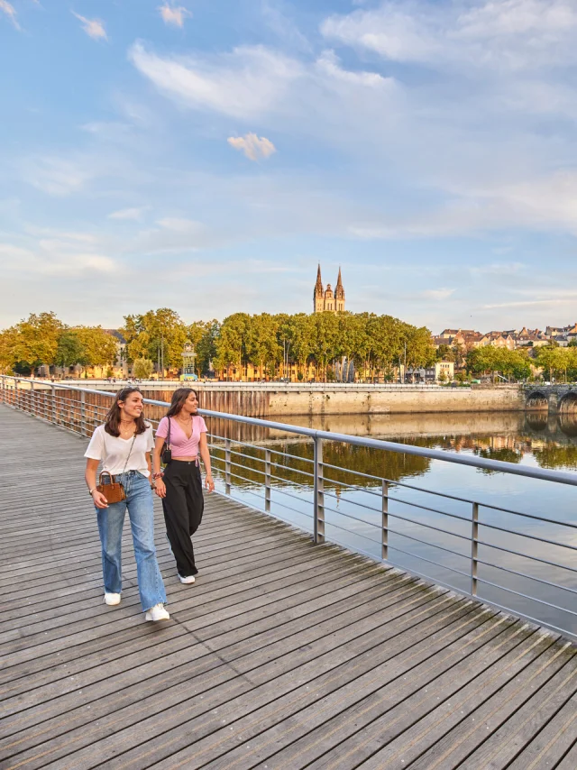 Deux jeunes femmes en tee-shirts, marchant sur le pont en fin de journée