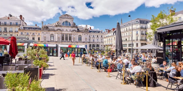 Vue d'ensemble de la place du Ralliement, terrasses des restaurants bondées au premier plan, tram et grand théâtre à l'arrière-plan