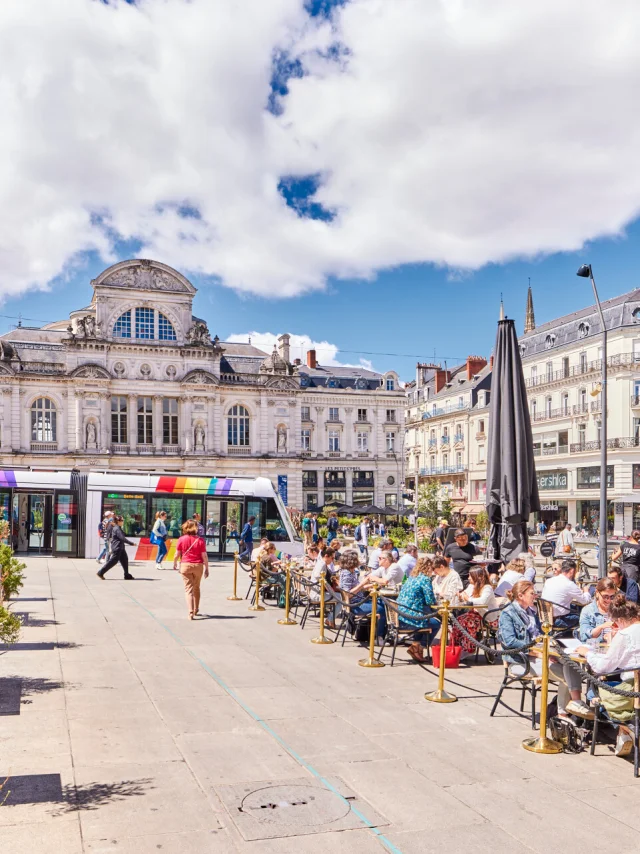 Vue d'ensemble de la place du Ralliement, terrasses des restaurants bondées au premier plan, tram et grand théâtre à l'arrière-plan