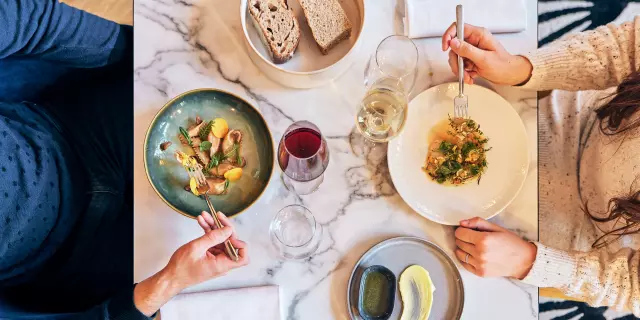 Vue en plongée sur une table de restaurant dont les plats sont servis pour un homme et une femme