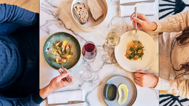 Vue en plongée sur une table de restaurant dont les plats sont servis pour un homme et une femme