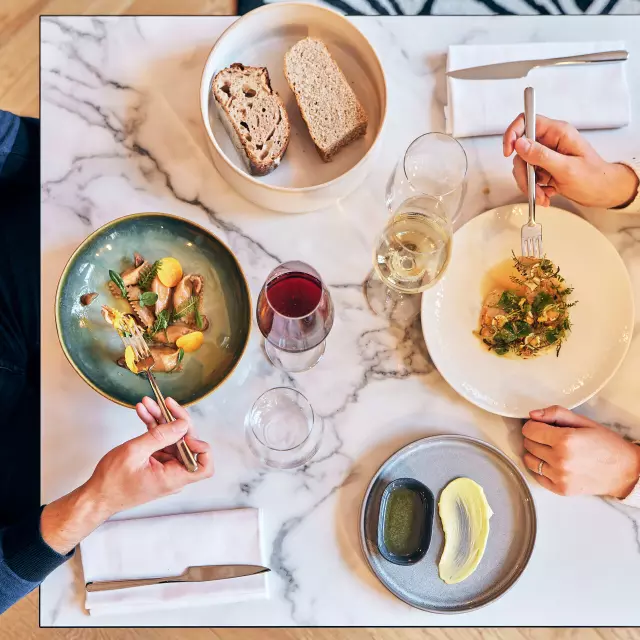 Vue en plongée sur une table de restaurant dont les plats sont servis pour un homme et une femme