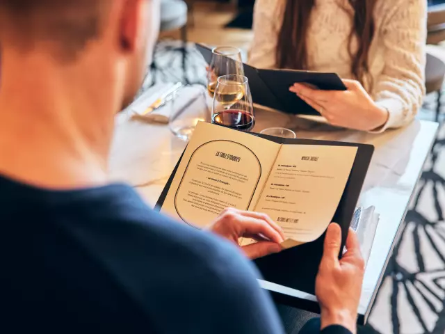 Vue au-dessus de l'épaule d'un homme qui lit la carte du restaurant