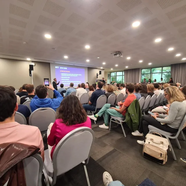 Assemblée de personnes assises dans une salle et assistant à un atelier